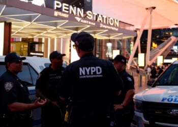 New York City police officers gather outside Penn Station on Sunday after a stabbling that left five wounded.