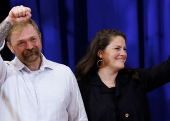 Democratic Maine U.S. Senate candidate Graham Platner and his wife Amy Gertner wave to supporters as they arrive at Platner's Primary Election event on June 9 in Blue Hill, Maine.