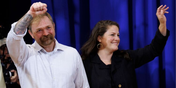 Democratic Maine U.S. Senate candidate Graham Platner and his wife Amy Gertner wave to supporters as they arrive at Platner's Primary Election event on June 9 in Blue Hill, Maine.