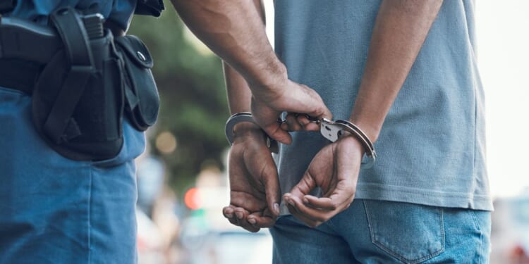 A police officer handcuffs a suspect.