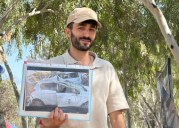 Survivor from the NOVA Music Festival massacre that happened on Oct. 7, 2023, shows a picture of his car, damaged by Hamas fire.