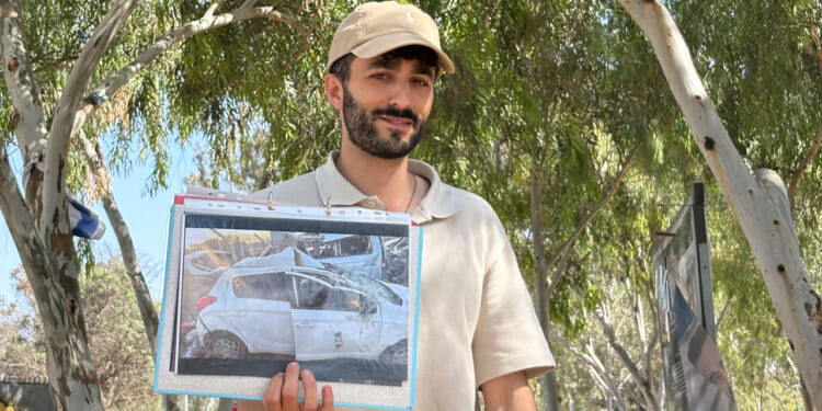 Survivor from the NOVA Music Festival massacre that happened on Oct. 7, 2023, shows a picture of his car, damaged by Hamas fire.