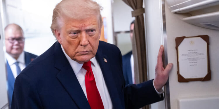 President Donald Trump speaks to reporters on Air Force One.