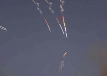 Iranian missiles streak against a dark sky.