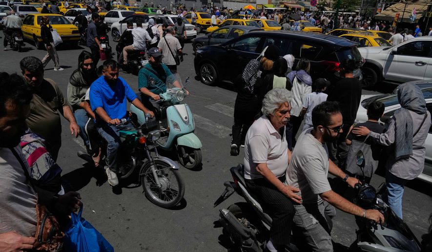 Pedestrians and vehicles cross an intersection around Tehran's historic Grand Bazaar, Iran, Monday, June 1, 2026. (AP Photo/Vahid Salemi)