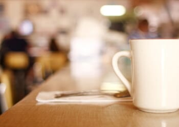 A cup of coffee on a counter in a diner.