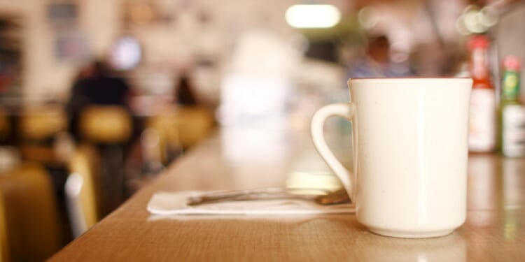 A cup of coffee on a counter in a diner.