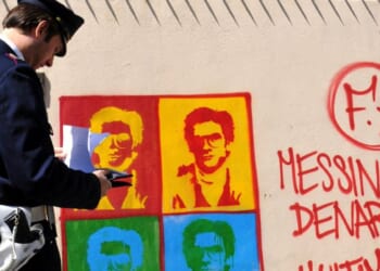 An Italian officer takes notes on graffiti of Matteo Messini Denaro on April 24, 2008.