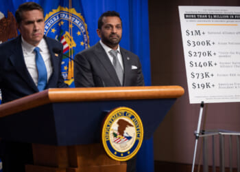 Todd Blanche at a podium with Kash Patel at his side as they announce charges against SPLC.