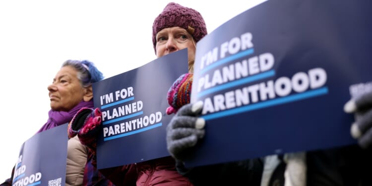 Protesters holding Planned Parenthood signs
