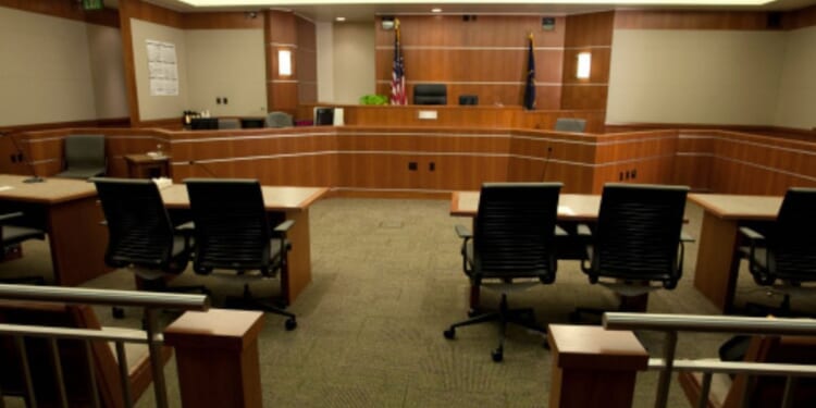 A modern courtroom sits empty under dim lights.