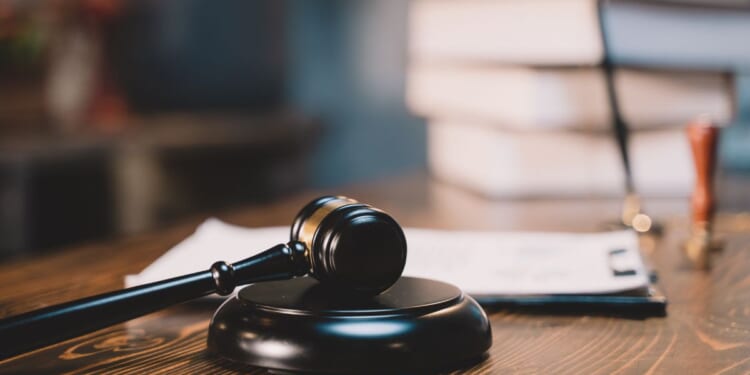 A gavel sits on top of a judge's desk.