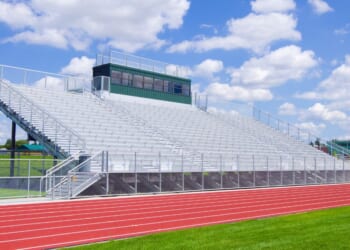 Bleachers at a high school football field with track.