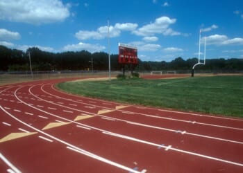 A high school running track and field with a goal post.