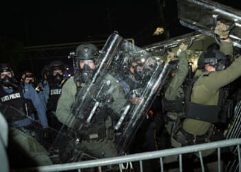Law enforcement officers fend off anti-ICE protesters during a clash outside the Delaney Hall detention center on Saturday in Newark, N.J.