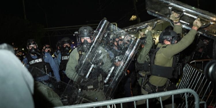 Law enforcement officers fend off anti-ICE protesters during a clash outside the Delaney Hall detention center on Saturday in Newark, N.J.