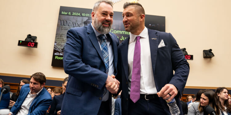 Tim Tebow, Founder of the Tim Tebow Foundation is greeted by Jim Cole, retired Homeland Security Investigations supervisor.