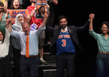 Claire Valdez, Brad Lander, Mayor Zohran Mamdani, and Darializa Avila Chevalier raise their hands on stage during a rally.