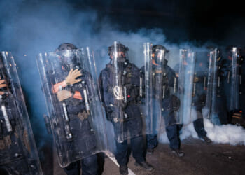 New Jersey State Police stand guard in front of protesters outside Delaney Hall which is being used as an ICE detention center. (Photo by Adam Gray/Getty Images)