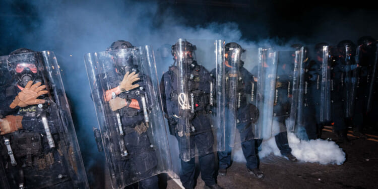 New Jersey State Police stand guard in front of protesters outside Delaney Hall which is being used as an ICE detention center. (Photo by Adam Gray/Getty Images)