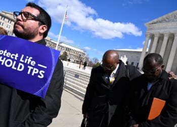 Viles Dorsainvil, Executive Director of the Haitian Support Center, and Associate Pastor Brandon Peterson of Greater Grace Temple in Springfield, Ohio, listen to a prayer outside the US Supreme Court.