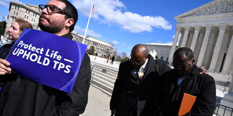 Viles Dorsainvil, Executive Director of the Haitian Support Center, and Associate Pastor Brandon Peterson of Greater Grace Temple in Springfield, Ohio, listen to a prayer outside the US Supreme Court.