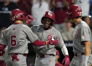 Kyle Branch of the Oklahoma Sooners is congratulated by Dasan Harris and Brendan Brock after hitting a home run during the eighth inning against the North Carolina Tar Heels in Game 3 of the NCAA College World Series baseball finals at Charles Schwab Field on June 22, 2026, in Omaha, Nebraska.