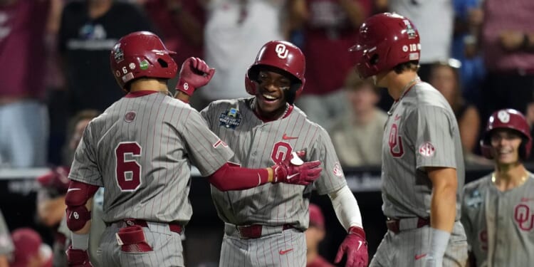 Kyle Branch of the Oklahoma Sooners is congratulated by Dasan Harris and Brendan Brock after hitting a home run during the eighth inning against the North Carolina Tar Heels in Game 3 of the NCAA College World Series baseball finals at Charles Schwab Field on June 22, 2026, in Omaha, Nebraska.