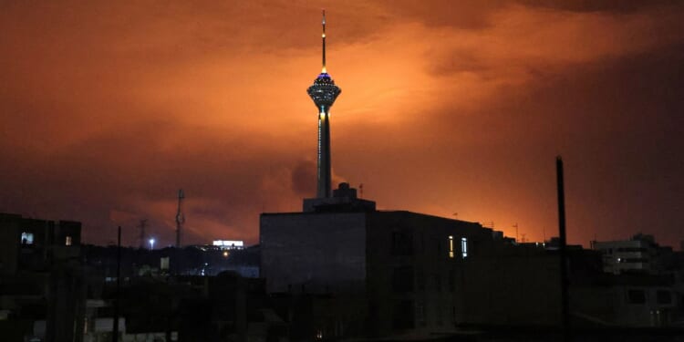 Milad (Birth) Tower, the tallest tower in Iran at 435 metres, is pictured before a lit up sky following airstrikes in Tehran on March 7.