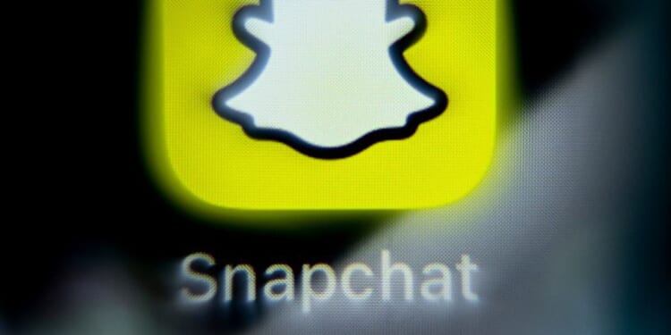 The Snapchat logo is displayed on a phone screen.