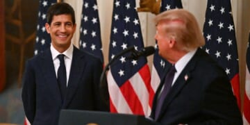 Donald Trump and Kevin Warsh in front of several American flags.