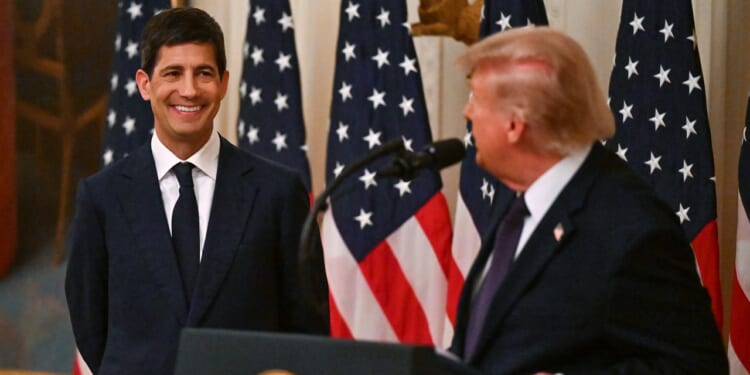 Donald Trump and Kevin Warsh in front of several American flags.