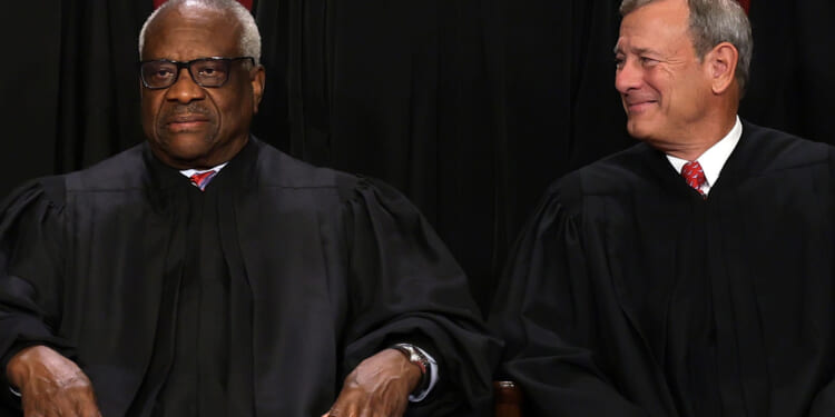 WASHINGTON, DC - OCTOBER 07: United States Supreme Court Associate Justice Clarence Thomas (L) and Chief Justice of the United States John Roberts (R) pose for their official portrait at the East Conference Room of the Supreme Court building on October 7, 2022 in Washington, DC. The Supreme Court has begun a new term after Associate Justice Ketanji Brown Jackson was officially added to the bench in September. (Photo by Alex Wong/Getty Images)