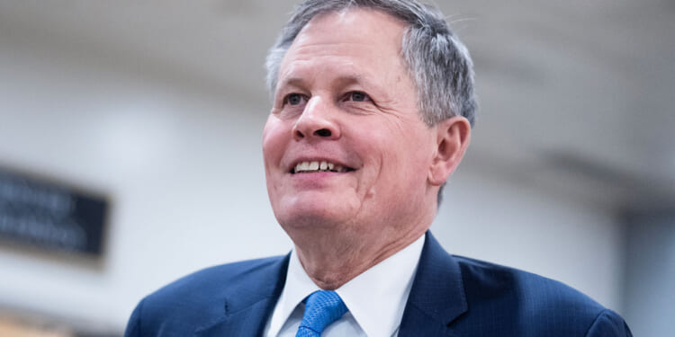 Sen. Steve Daines stands and smiles.