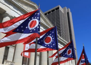 State of Ohio flags waving in front of the State House in Columbus, Ohio.