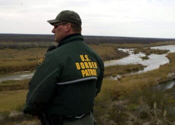 Border Patrol agent looks out at a vista