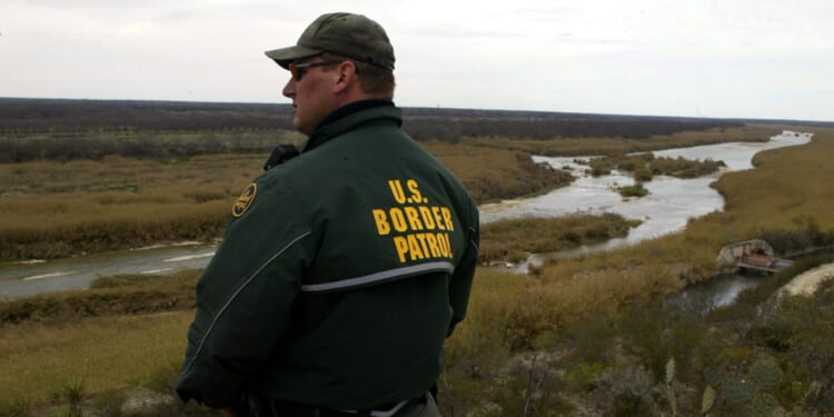 Border Patrol agent looks out at a vista