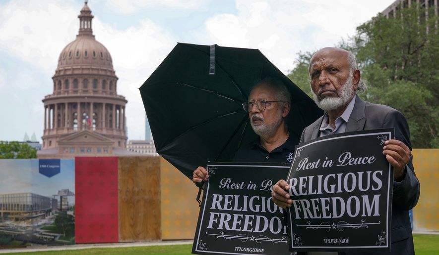 Mohammed Nasrullah, left, and Aziz Soomro, both of Houston, participate in an interfaith funeral-themed protest outside the Barbara Jordan Building in Austin on Monday, June 22, 2026. (Jay Janner/Austin American-Statesman via AP)