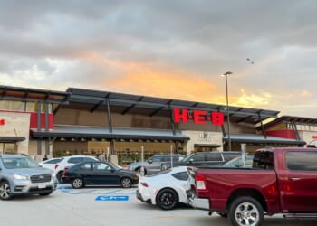 The view from parking lots to the store entrance of a recently opened H-E-B Grocery Company franchise supermarket chain with busy traffic at sunset in Plano, Texas, on July 8, 2023.