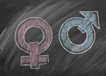 Two gender symbols are drawn on a chalkboard. One for male, and one for female.