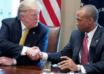 Donald Trump shaking the hand of Department of Housing and Urban Development Secretary Scott Turner. Turner condemned "fraud" in Los Angeles housing.