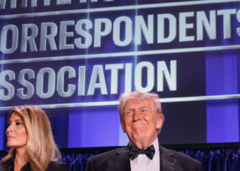 A beaming Donald Trump along with Melania Trump stand at the White House Correspondents' Association dinner.