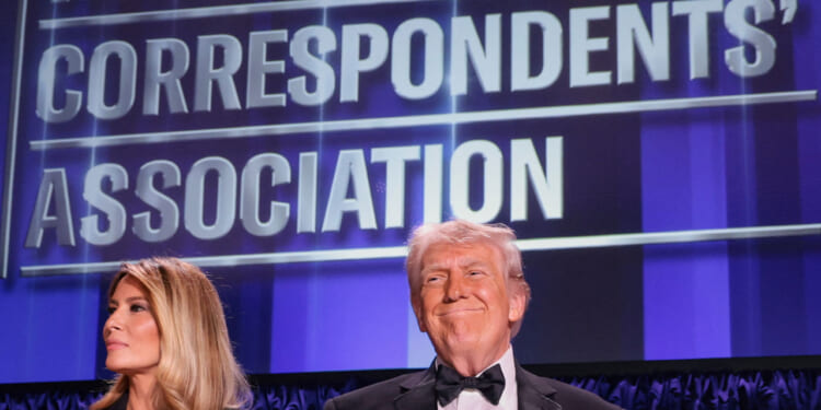 A beaming Donald Trump along with Melania Trump stand at the White House Correspondents' Association dinner.