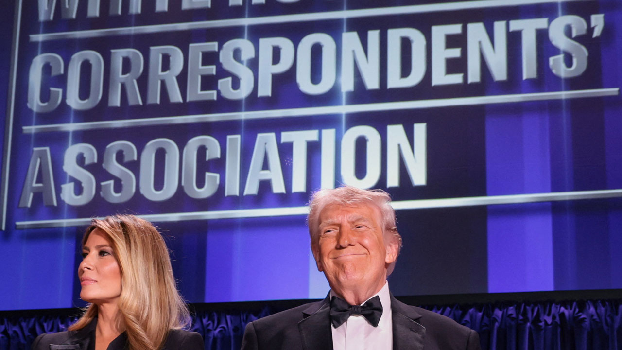 A beaming Donald Trump along with Melania Trump stand at the White House Correspondents' Association dinner.