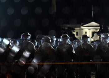 Police officers hold a perimeter behind the metal fence recently erected in front of the White House demonstrators gather to protest the killing of George Floyd on June 2, 2020, in Washington, D.C.