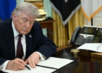 President Donald Trump is pictured in a March 31 photo signing an executive order in the Oval Office of the White House.