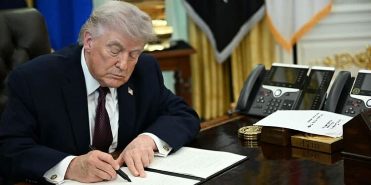 President Donald Trump is pictured in a March 31 photo signing an executive order in the Oval Office of the White House.