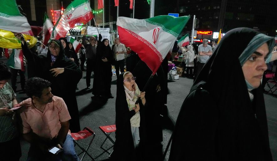 A girl waves an Iranian flag in a pro-government gathering in Tehran, Iran, Sunday, June 7, 2026. (AP Photo/Vahid Salemi)
