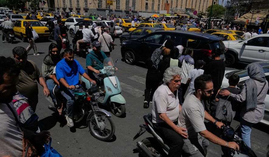 Pedestrians and vehicles cross an intersection around Tehran's historic Grand Bazaar, Iran, Monday, June 1, 2026. (AP Photo/Vahid Salemi)