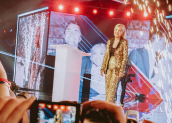 Turning Point USA CEO Erika Kirk, widow of right-wing political activist Charlie Kirk, speaks on a stage.